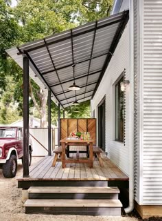 a picnic table on the back porch of a mobile home with stairs leading up to it