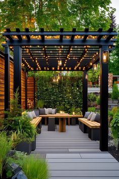 an outdoor seating area with wooden benches and lights on the pergolated roof, surrounded by greenery