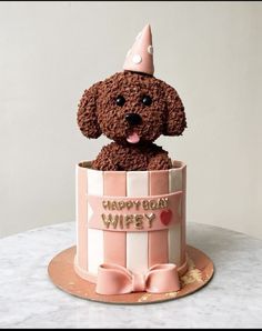 a cake shaped like a dog in a birthday hat