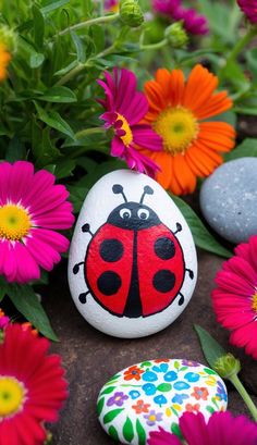 a painted rock with a lady bug on it surrounded by flowers