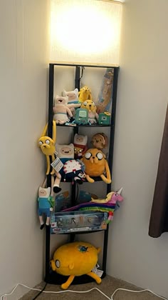 a shelf filled with stuffed animals next to a wall mounted light on top of a carpeted floor