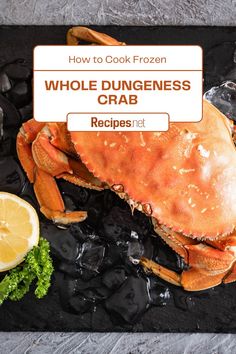 a large crab sitting on top of ice next to lemons and other food items