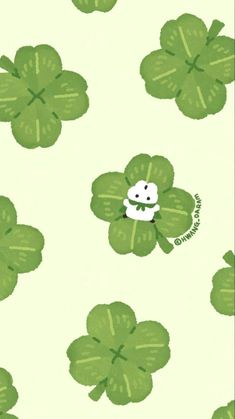 a green clover pattern with a white dog on it's back and four leaf clovers in the background