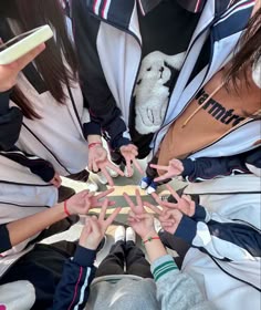 a group of people standing in a circle with their hands on top of each other