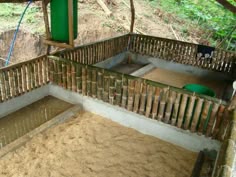 an animal pen with sand and water in it