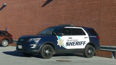 a sheriff car parked in front of a brick building