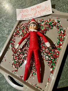 an elf with sprinkles on it laying in a tray