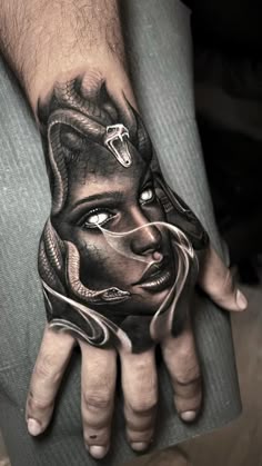 a man's hand with a black and white tattoo on it