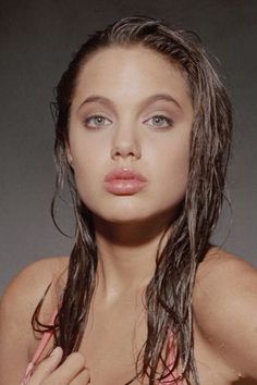 a woman with wet hair is posing for the camera and has her hands on her chest