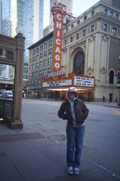 a woman standing in front of the chicago theatre