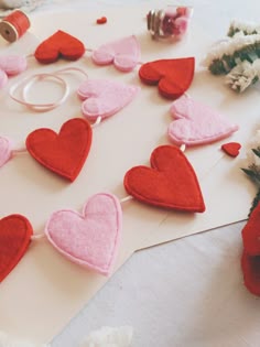 red and pink felt heart garland on white table