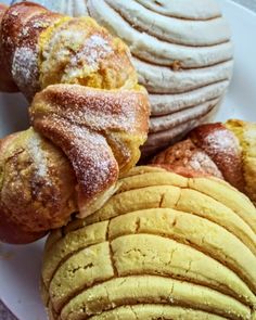 a white plate topped with pastries covered in powdered sugar