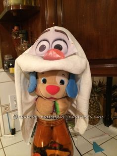 a stuffed animal with a hat on top of it's head in a kitchen