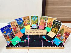 there is a display with many different books on the table and one has a sign that says welcome to the land of festivity