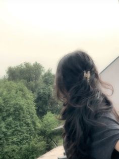 a woman with long hair sitting on a bench