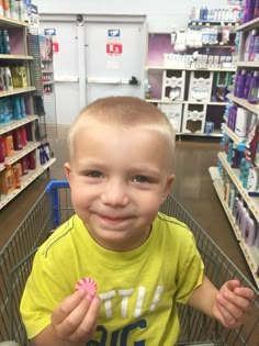 a little boy that is sitting in a shopping cart with some kind of food on it