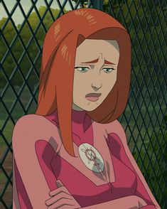 a woman with red hair standing in front of a fence and looking at the camera