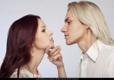 two people standing next to each other and one is touching the other's nose