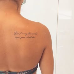 a woman with a tattoo on her back saying, don't worry the world you are watching
