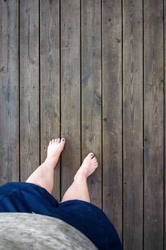 a person laying on top of a wooden floor next to a wood planked wall