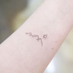 a small tattoo on the arm of a woman's left arm, with an arrow