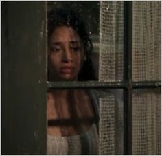 a woman looking through a window at something