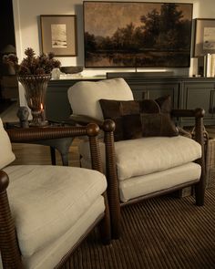 a living room filled with furniture and a painting on the wall