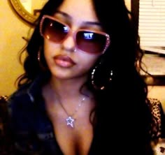 a woman wearing sunglasses is posing for the camera