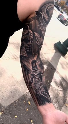 a man with a black and grey tattoo on his arm