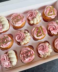 twelve cupcakes with pink frosting and happy birthday written on them in a box