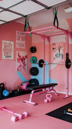 a pink gym room with exercise equipment on the floor