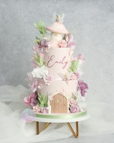 Pretty flower garden cake featuring a toadstool house, fairy door and two little fairies.
Lots of wafer flowers and leaves, painted grass and simple sugar flowers.
Pale pink two tier cake with a hand painted name in script