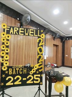 there is a sign that says farewell and balloons in front of the wall behind it