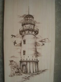 a drawing of a lighthouse with birds flying around it on a piece of wooden paper