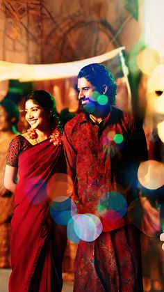 a man and woman standing next to each other in front of some balloons with lights on them