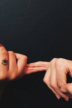 two hands reaching for each other with one hand holding the other's wrist tattoo