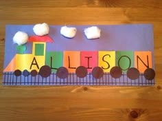 a paper train with the name allison written on it and some clouds in the sky