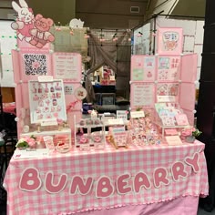 a table with pink and white checkered cloth on it, surrounded by pictures and cards