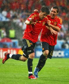 two soccer players in the rain celebrating