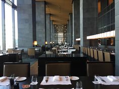 an empty restaurant with tables and chairs in front of large windows that overlook the city