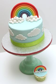 there is a cake with rainbows on it and a cupcake next to it