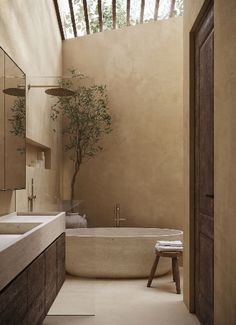a bathroom with a tree in the corner and a bathtub on the other side