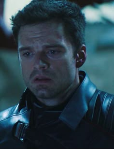 a man in black leather jacket looking at the camera with an angry look on his face
