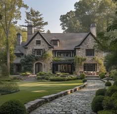 a large stone house surrounded by lush green trees
