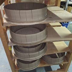 several different types of tires are stacked on wooden shelves and ready to be used as planters