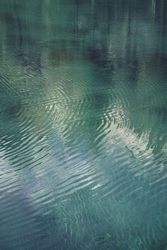 the water is very clear and blue with ripples on it's surface,