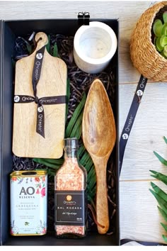 an open box containing spices, spoons and utensils on a wooden table