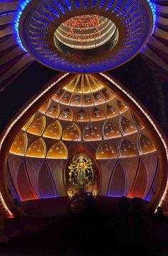 the inside of a building with lights and decorations on it's ceiling, including a clock