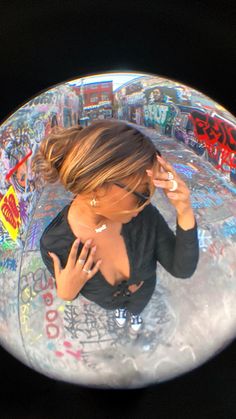 a woman is sitting in a bubble with graffiti on it