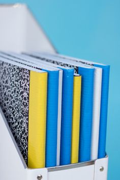 several binders are stacked on top of each other in front of a blue background